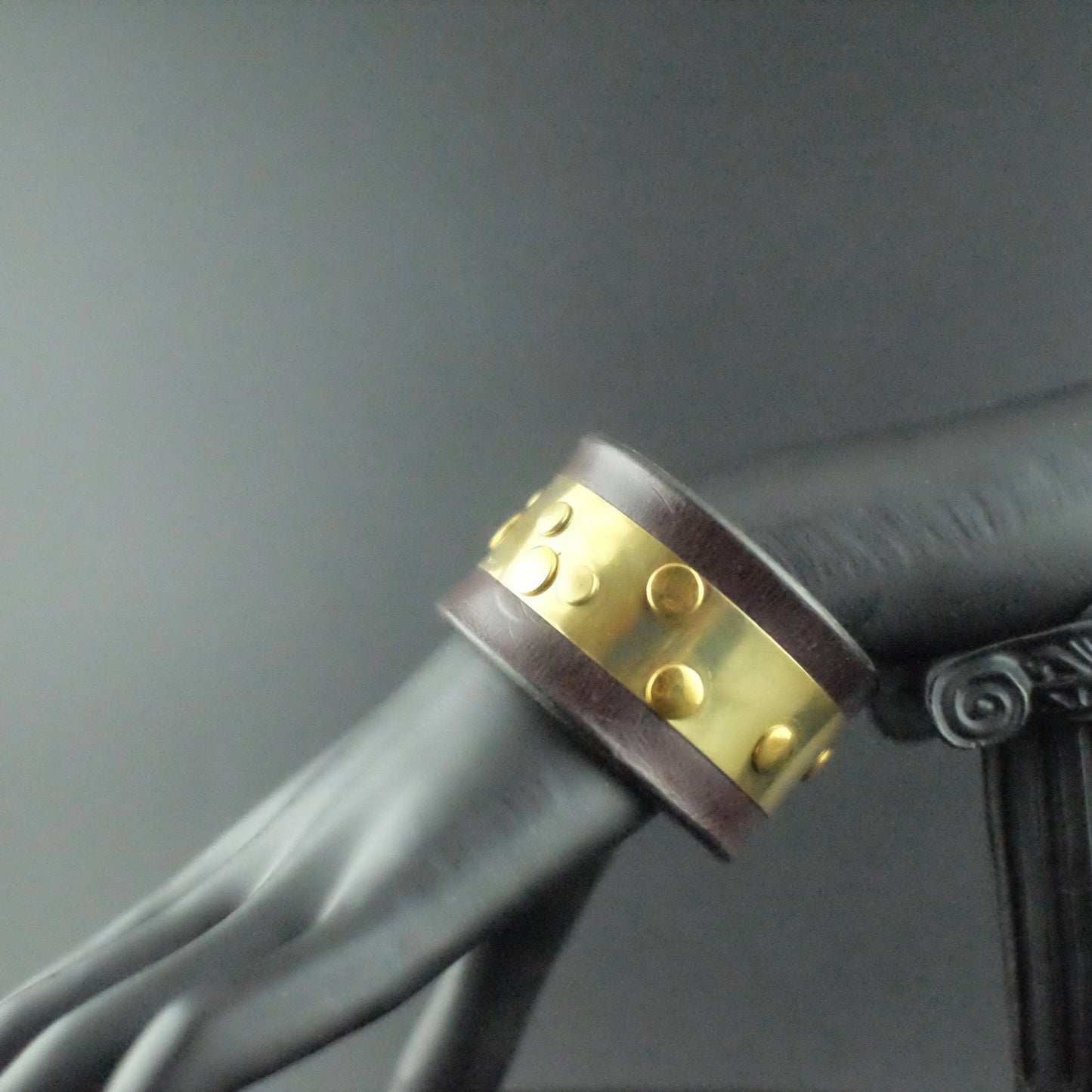Genuine leather bracelet with metal brass strip and rivets throughout 