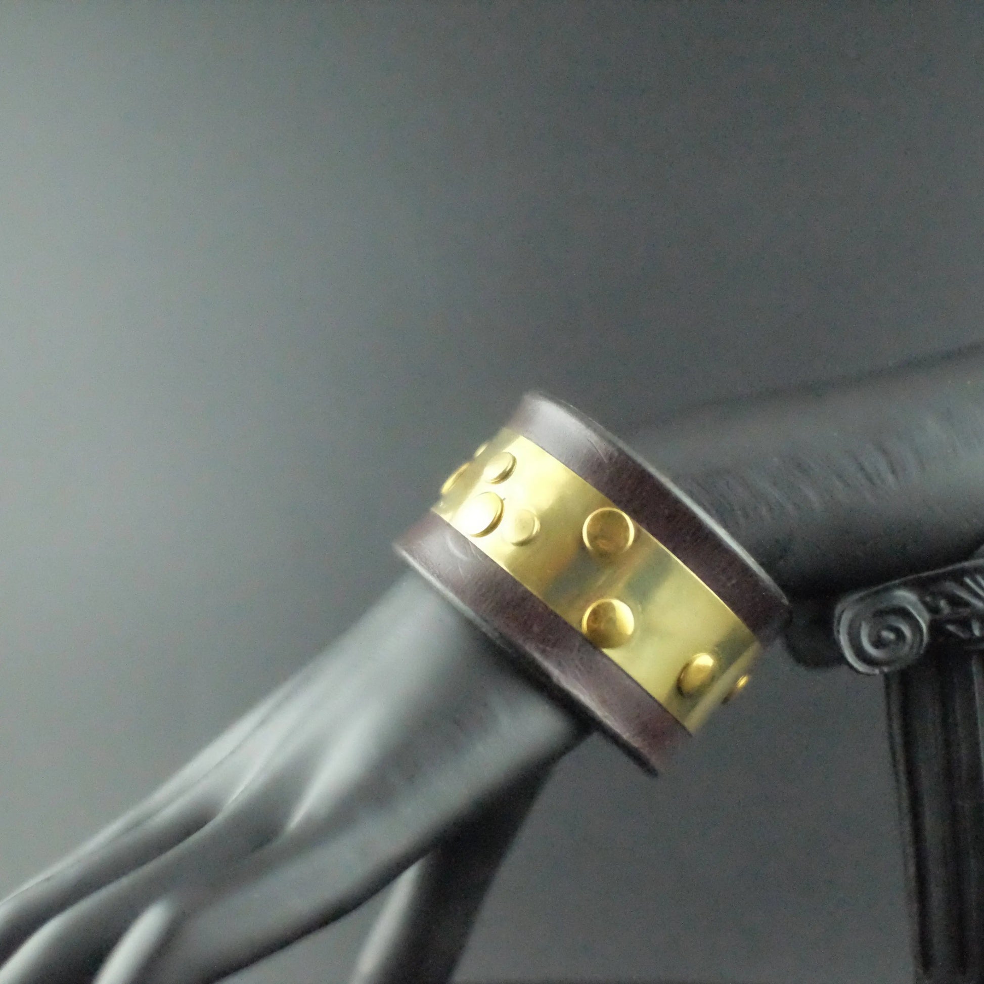 Genuine leather bracelet with metal brass strip and rivets throughout 