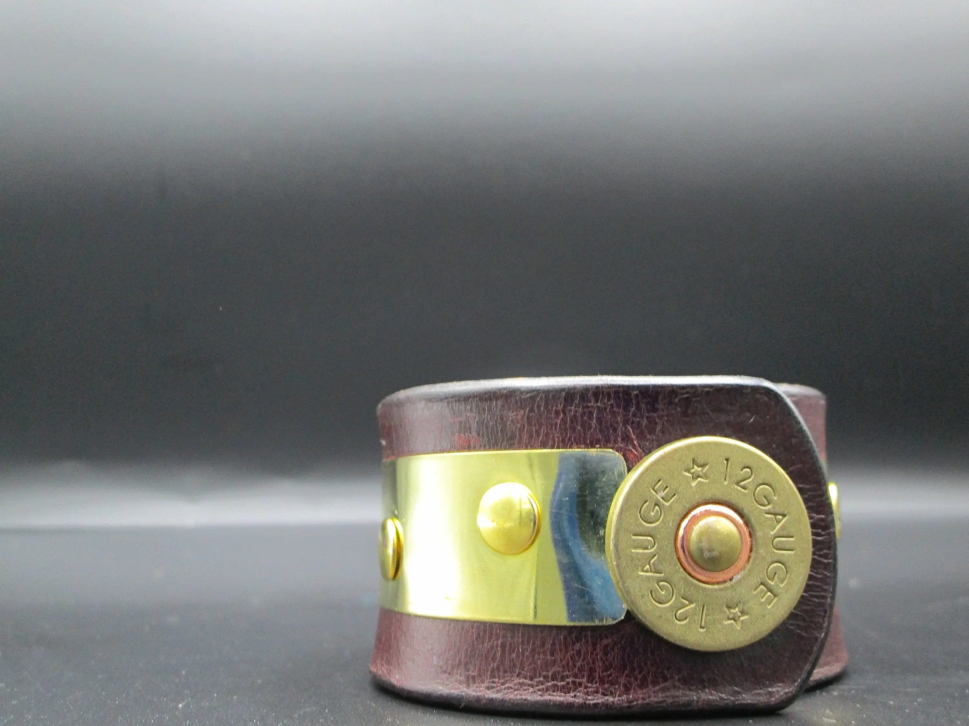 close up of genuine brown  leather bracelet  with 12 gauge bullet shell snap facing forward